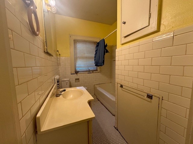 full bathroom with vanity, tile walls, shower / bath combo with shower curtain, and toilet