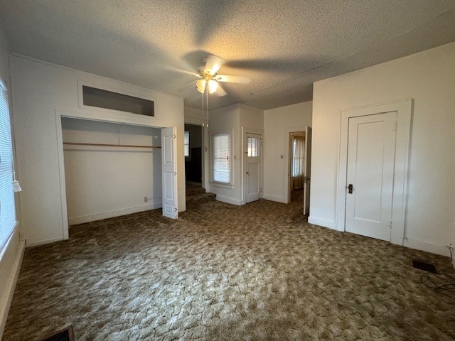 unfurnished bedroom featuring ceiling fan, carpet flooring, and a textured ceiling