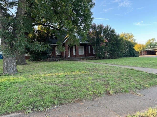 obstructed view of property with a front lawn