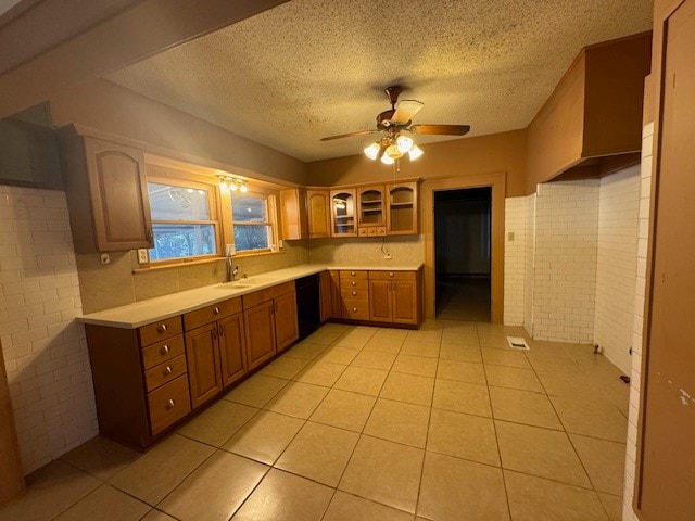 kitchen featuring dishwasher, ceiling fan, brick wall, and light tile patterned floors