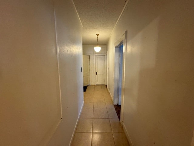 hall featuring a textured ceiling and light tile patterned floors