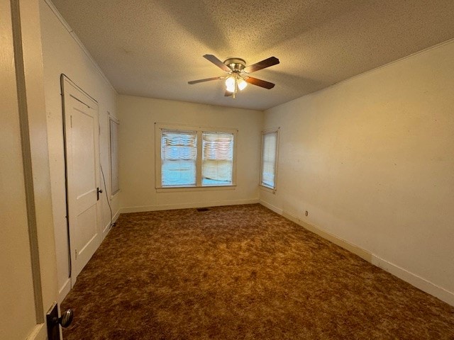 empty room featuring ceiling fan, carpet floors, and a textured ceiling