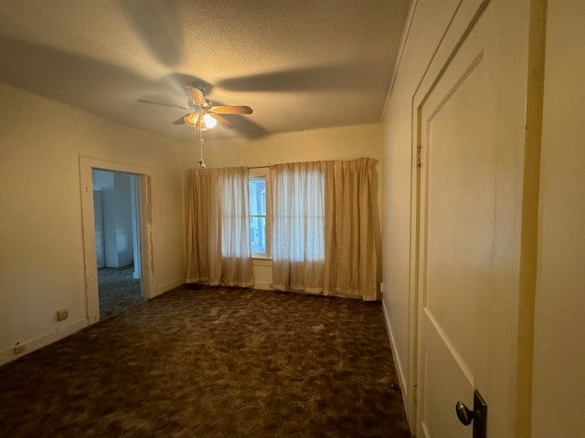 carpeted empty room with ceiling fan and a textured ceiling