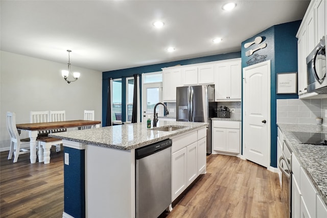 kitchen featuring stainless steel appliances, white cabinetry, hardwood / wood-style flooring, and sink