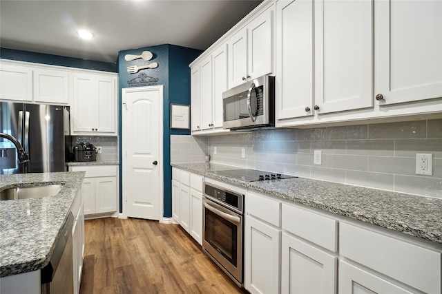 kitchen with white cabinets, hardwood / wood-style flooring, and stainless steel appliances