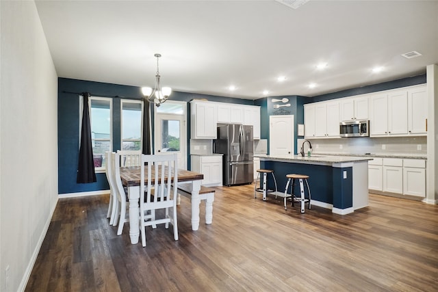 dining space with hardwood / wood-style floors, sink, and a notable chandelier