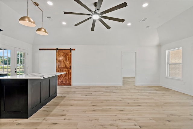 kitchen with ceiling fan, light wood-type flooring, hanging light fixtures, and a barn door