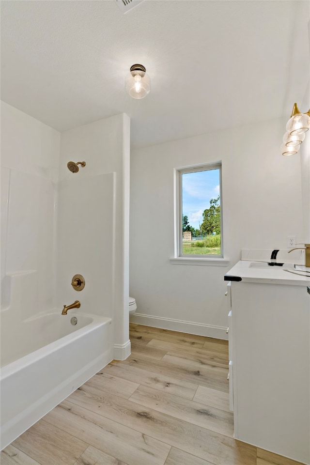 full bathroom featuring shower / washtub combination, wood-type flooring, vanity, and toilet