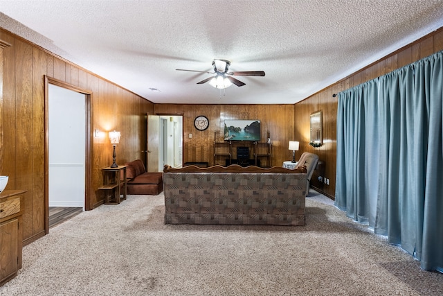 living room with ceiling fan, carpet flooring, and a textured ceiling