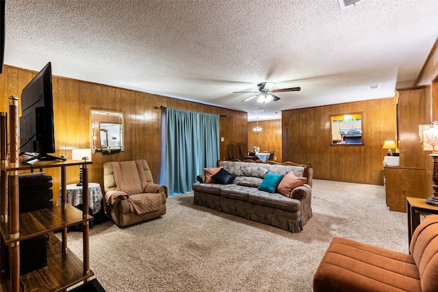 living room featuring a textured ceiling, wooden walls, light carpet, and ceiling fan