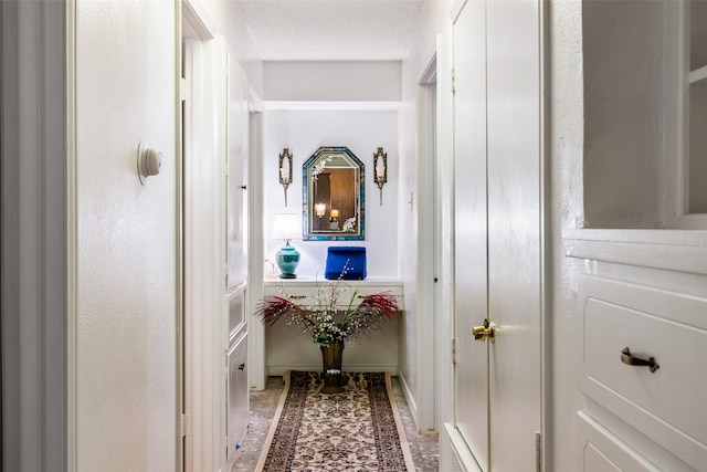 hall with a textured ceiling