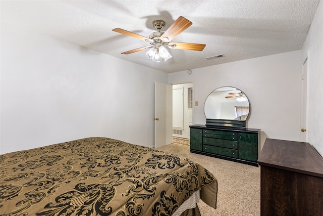 carpeted bedroom featuring a textured ceiling and ceiling fan