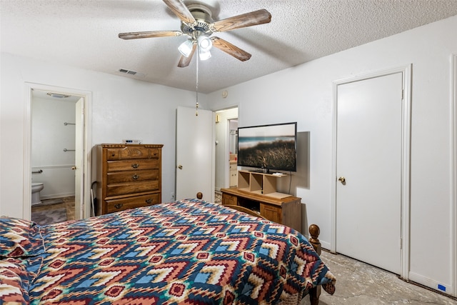 bedroom featuring ceiling fan, ensuite bathroom, and a textured ceiling