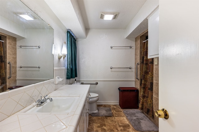 bathroom with a textured ceiling, vanity, toilet, and a shower with shower curtain