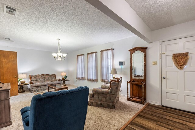 living room with a notable chandelier, a textured ceiling, and dark hardwood / wood-style flooring