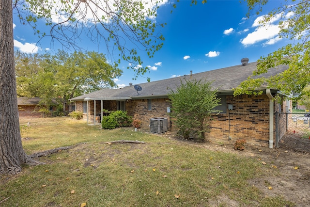 back of property featuring a yard and central AC