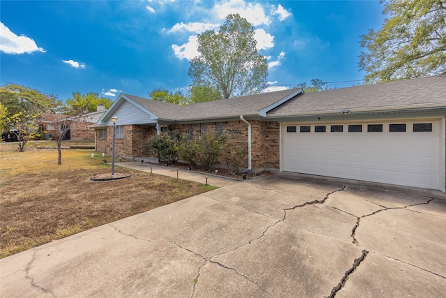 ranch-style home featuring a garage and a front lawn