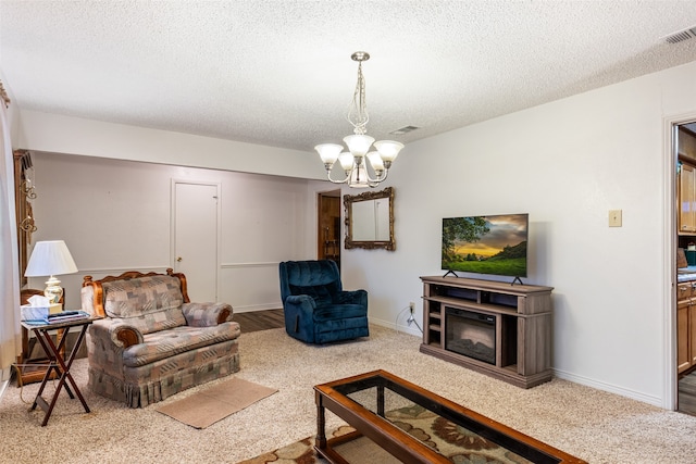 living room with a notable chandelier, a textured ceiling, and carpet flooring