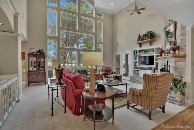 living room with ceiling fan, a fireplace, high vaulted ceiling, and a wealth of natural light