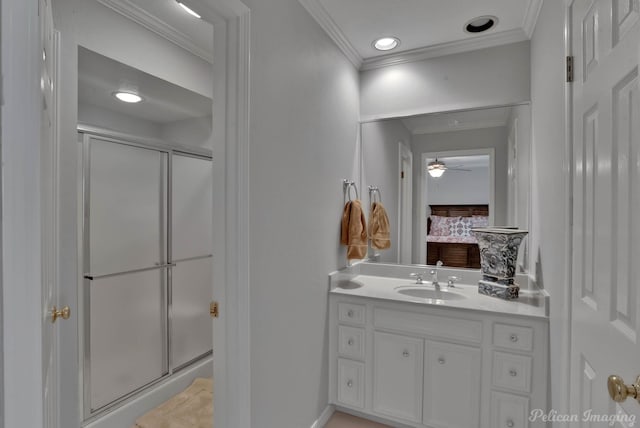 bathroom featuring vanity, ceiling fan, a shower with shower door, and crown molding