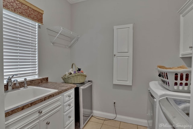 laundry room featuring cabinets, light tile patterned flooring, sink, and independent washer and dryer