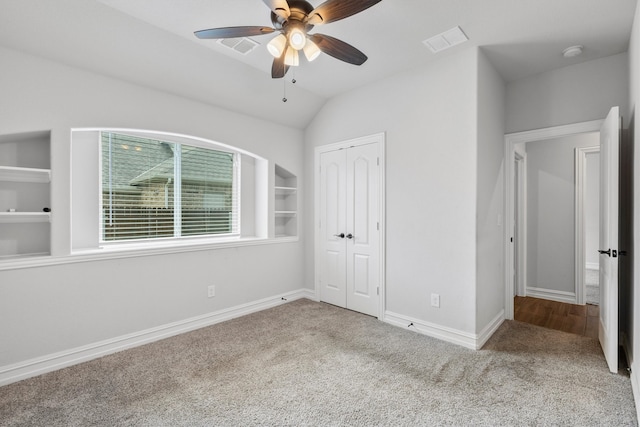 unfurnished bedroom featuring carpet flooring, vaulted ceiling, ceiling fan, and a closet