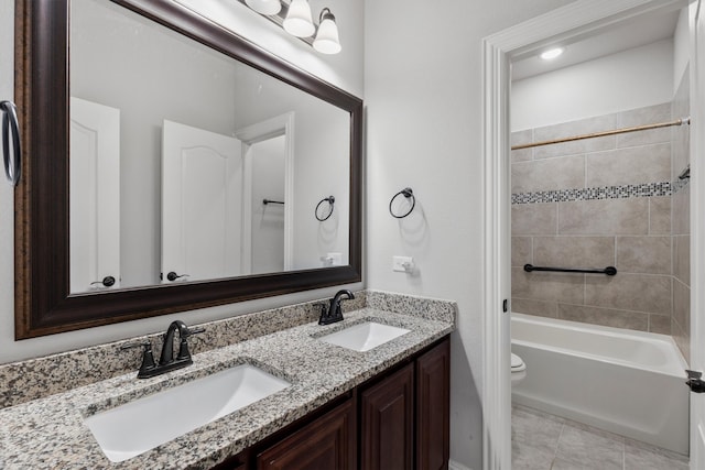 full bathroom featuring tiled shower / bath combo, tile patterned flooring, vanity, and toilet