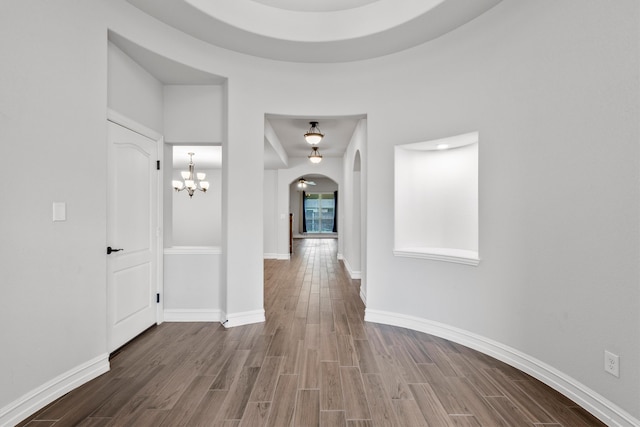 hall featuring a chandelier and hardwood / wood-style floors