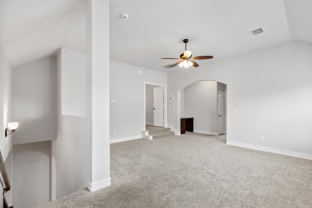 empty room featuring vaulted ceiling, ceiling fan, and carpet floors