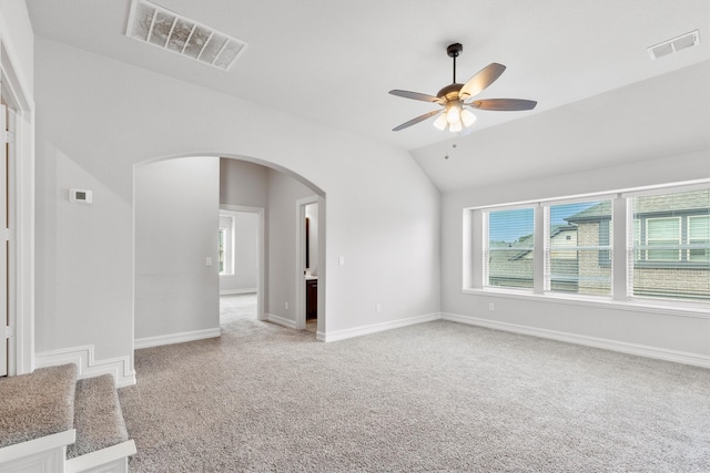 spare room with light carpet, vaulted ceiling, and ceiling fan