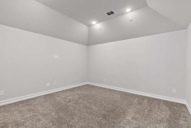 carpeted spare room featuring vaulted ceiling