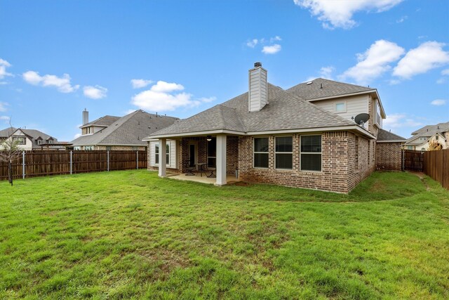 back of property with a lawn and a patio area