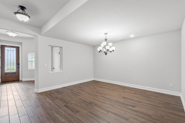 foyer entrance featuring an inviting chandelier and dark hardwood / wood-style flooring