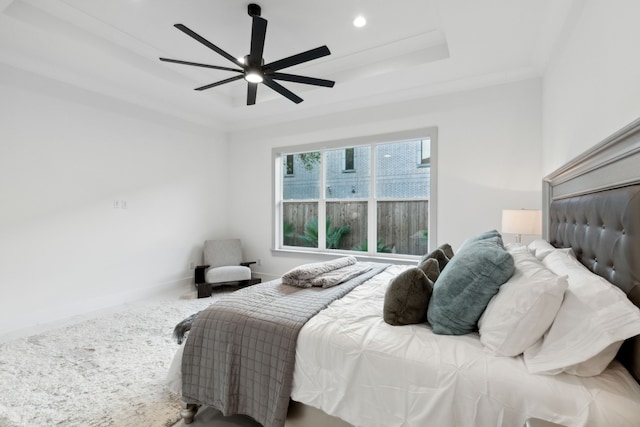 carpeted bedroom with crown molding, ceiling fan, and a raised ceiling