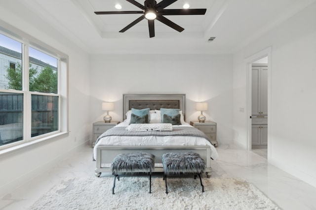 bedroom with ornamental molding, a tray ceiling, and ceiling fan