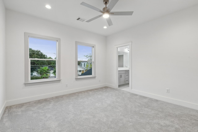 spare room featuring light carpet and ceiling fan