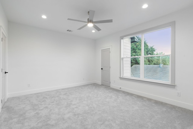 carpeted spare room featuring ceiling fan