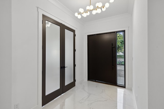 entryway with ornamental molding and an inviting chandelier