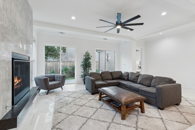 living room featuring ceiling fan and a fireplace