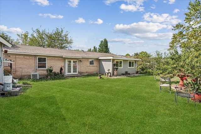 back of house with french doors, central air condition unit, and a lawn