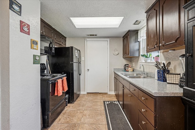 kitchen featuring light tile patterned flooring, sink, black appliances, a textured ceiling, and dark brown cabinets