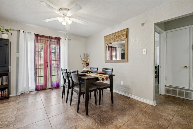 tiled dining room featuring a textured ceiling and ceiling fan