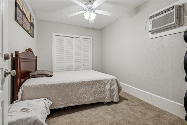 bedroom featuring a wall unit AC, ceiling fan, a closet, and carpet floors