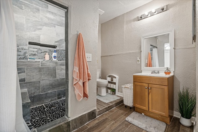 bathroom featuring toilet, vanity, hardwood / wood-style floors, and curtained shower