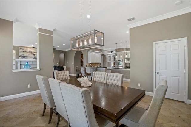 dining area featuring ornamental molding and ornate columns