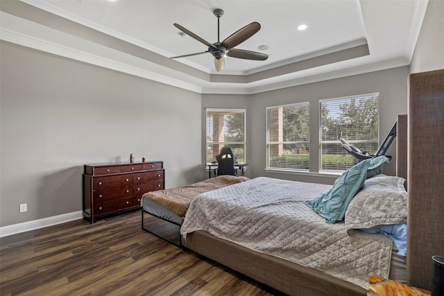 bedroom featuring dark hardwood / wood-style flooring, a tray ceiling, ceiling fan, and crown molding