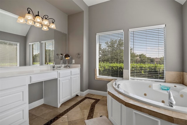 bathroom with a washtub, vanity, tile patterned floors, and a healthy amount of sunlight