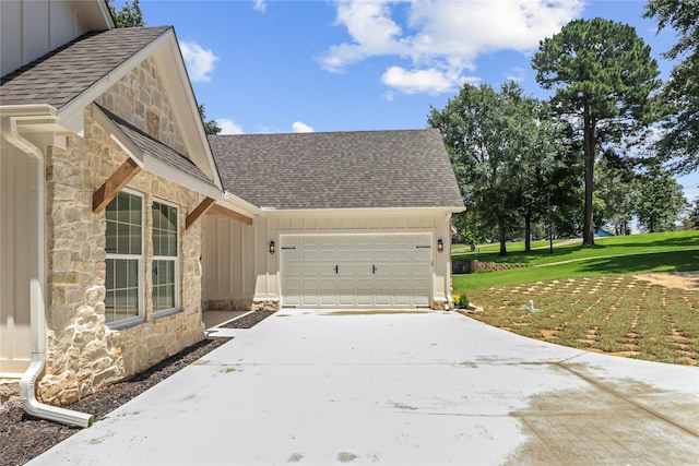 view of side of property featuring a garage and a lawn