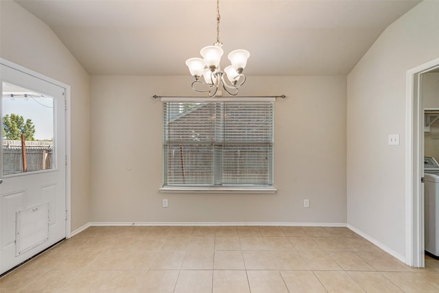 unfurnished dining area featuring an inviting chandelier, light tile patterned floors, and washer / dryer