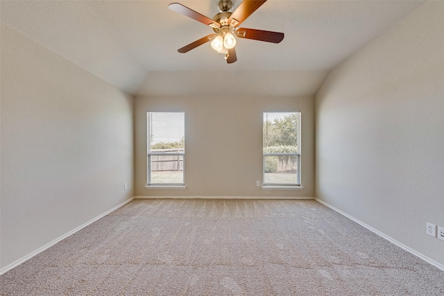 spare room with lofted ceiling, plenty of natural light, and light carpet